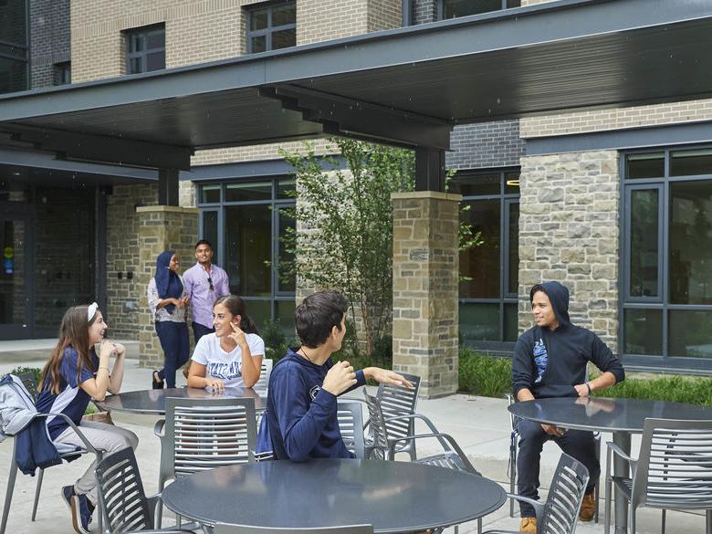 Students sitting outside of Lions Gate on Patio